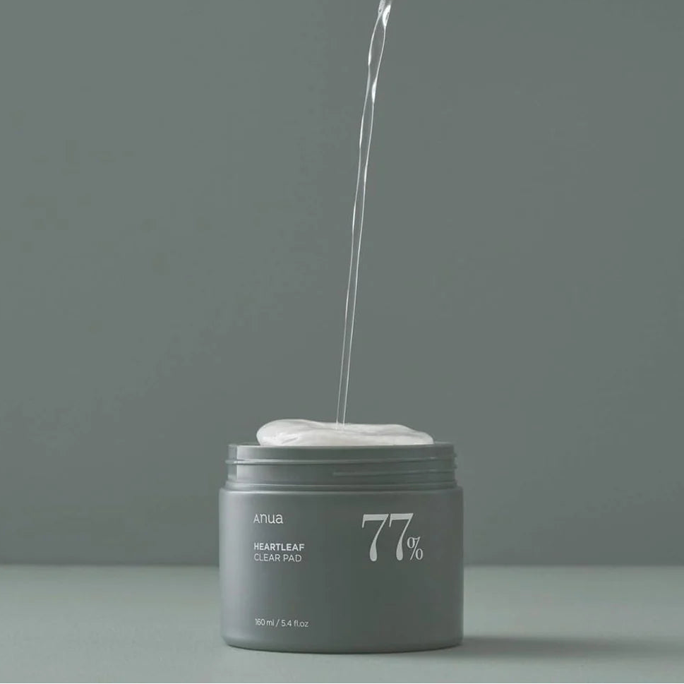 Clear liquid pouring into a gray jar labeled '77%', on a gray background