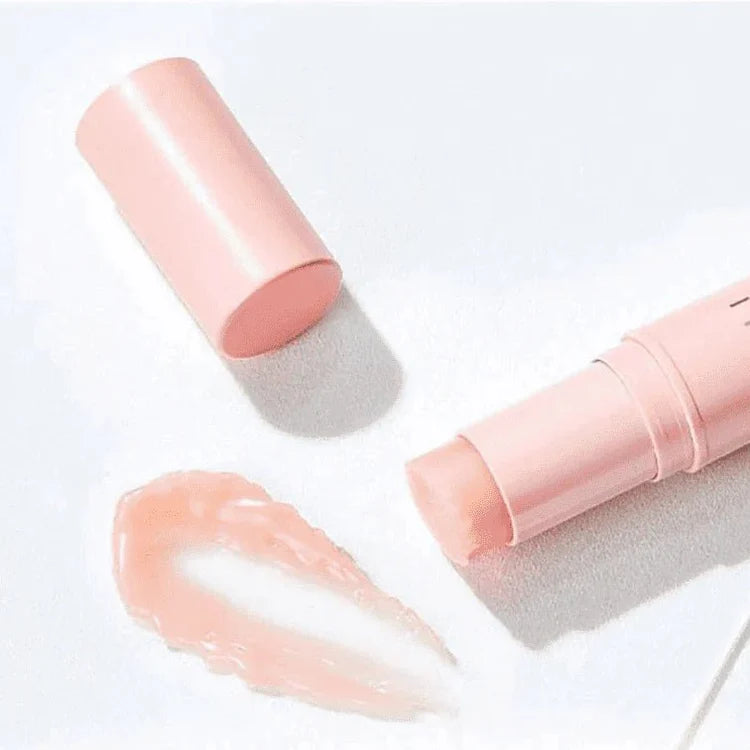 Pink makeup stick with applicator on a white background